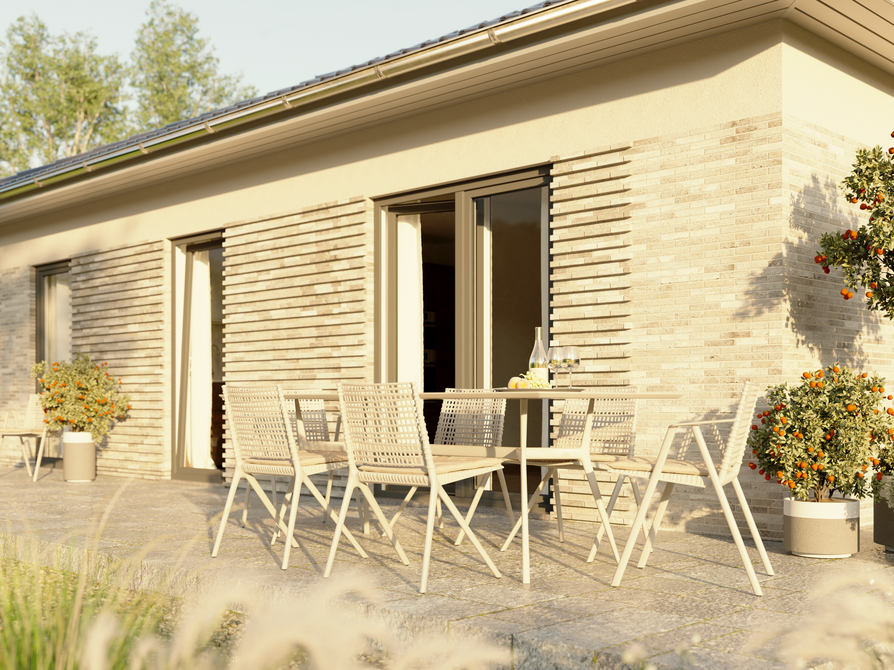 Detailansicht der Terrasse am Bungalow 78 mit harmonischem Materialmix aus heller Putzfläche und strukturierter Fassadenoptik, aufgenommen bei Tageslicht.